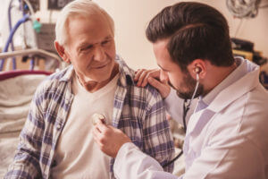 Doctor is listening to the heartbeat of a handsome old man using a stethoscope - most common types of cancer in colorado