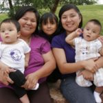 Family sitting in park happy