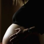 low lit close up of pregnant belly