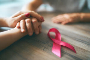 Females hands and symbol of Breast Cancer Awareness - most common types of cancer in colorado 