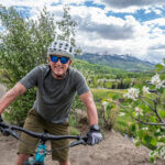 Man smiling and biking on floral trail