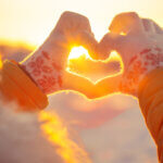 Woman hands in winter gloves Heart symbol shaped Lifestyle and Feelings concept with sunset light nature on background - mental preparation for the holidays featured image