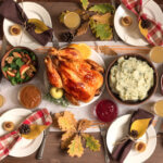 Thanksgiving Turkey Dinner with All the Sides. Homemade Roasted Turkey and all traditional dishes on Festive Thanksgiving table with autumnal decor. - tips for a healthier holiday