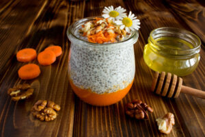 Pudding with chia,carrot,walnuts and honey on the brown wooden background - healthy winter breakfast ideas