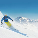 Man skier running downhill on sunny alpine slope