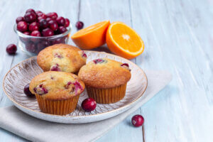 Homemade cranberry orange muffins on a wooden plate, horizontal, healthy winter breakfast ideas