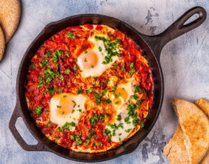 Shakshuka in a Frying Pan. Eggs Poached in Spicy Tomato Pepper Sauce. healthy winter breakfast ideas
