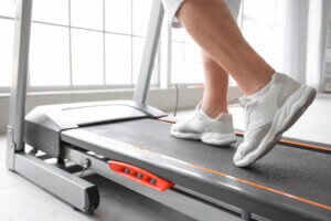 Close up of senior woman training on treadmill in gym