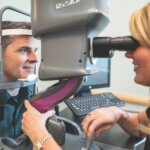 dr chance sanders inspecting a patient's eyes with light adjustable lenses