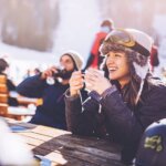 Happy skiers talking on a break in a cafe at mountain. sober curious